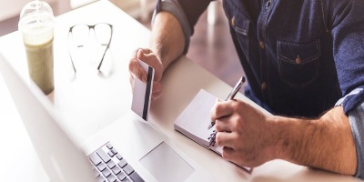 Man using a credit or debit card on his laptop computer