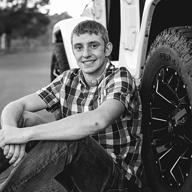 Young man leaning against his jeep